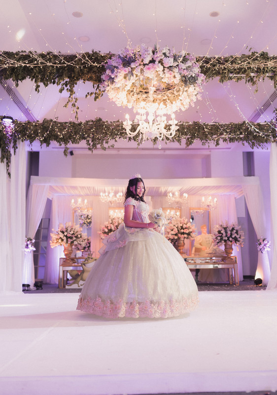 Quinceañera posando en sala decorada