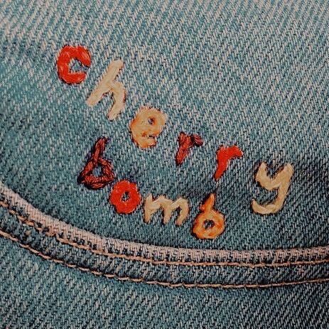 the words 'cherry bomb' embroided in denim