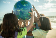 Hands holding Earth with people around