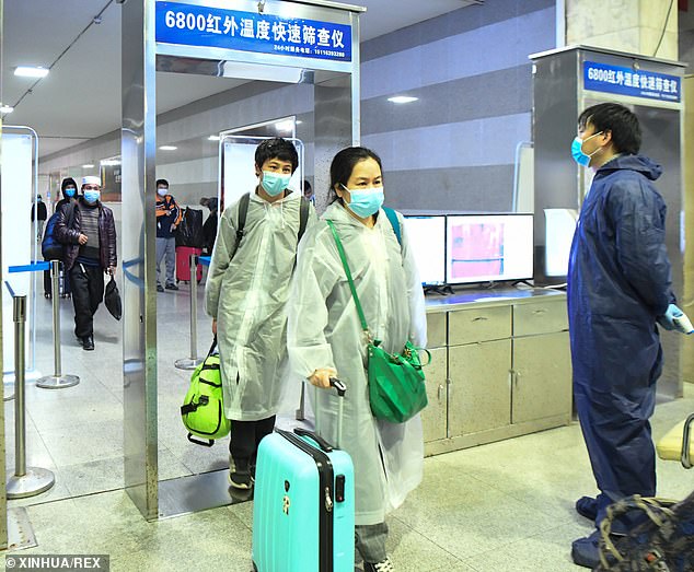 Penumpang dari Wuhan tiba melalui pos keamanan di stasiun Changsha pada Rabu (8/4/2020).