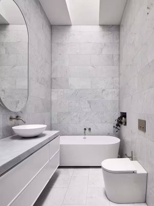 Primary bathroom with wall-hung double vanity, backlit mirrors, and large tile