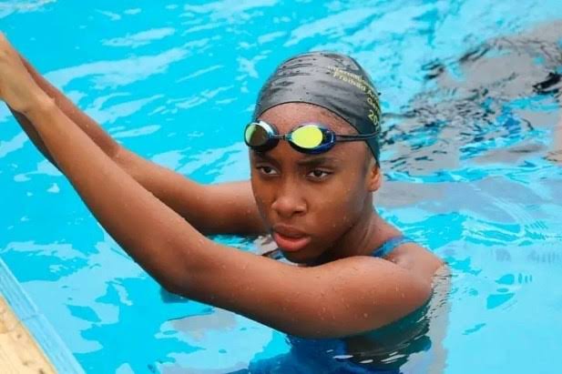 Black child swimming lessons in a pool