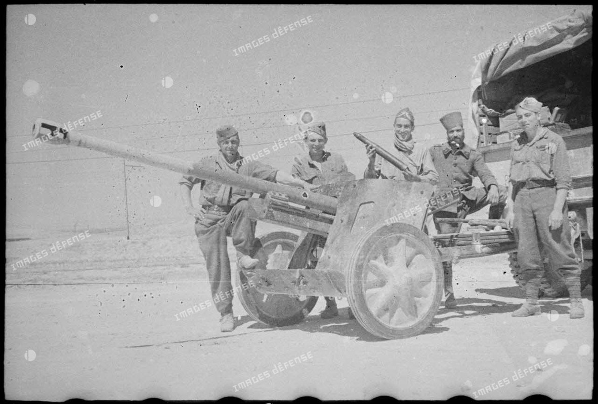 Des soldats du FSEA (Front du sud-est algérien) posent sur un canon antichar allemand Pak 38 de 5 cm
