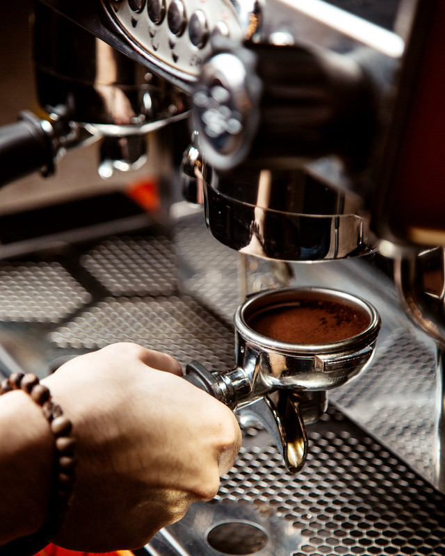 Barista brewing espresso on mechanical group head