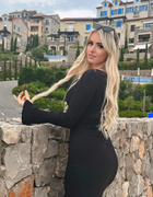 Chanel Cazzaniga, a stunning beautiful blonde lady in a sleek black dress, poses wi
