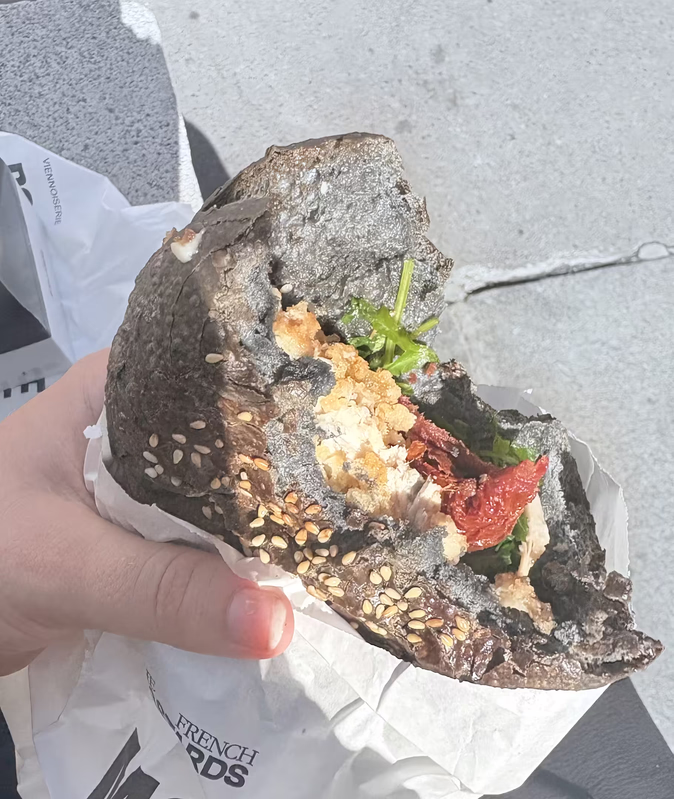 Black sesame croissant held in hand