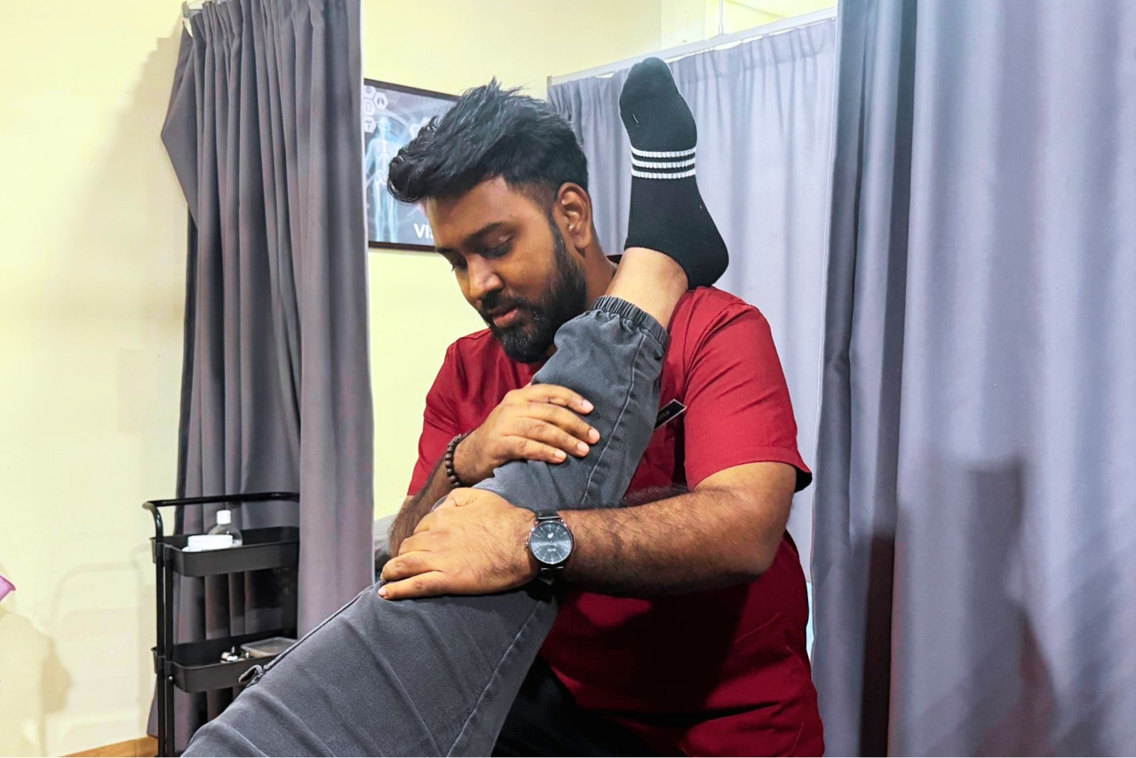Terapis melakukan manipulasi sendi pada pesakit di klinik