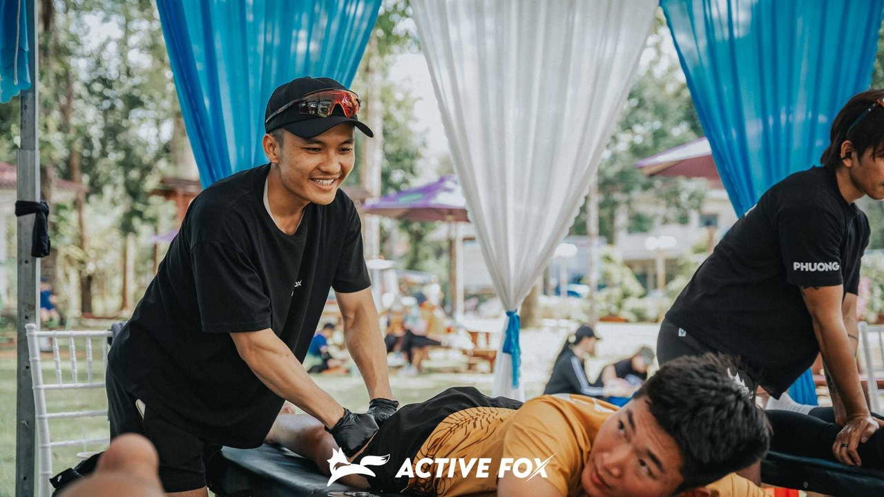 Kỹ thuật viên thực hiện massage thể thao cho vận động viên tại sự kiện của Active Fox
