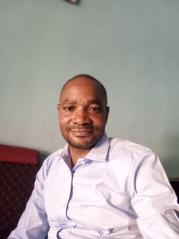 John Rodina, Co-Founder of MADEHub, smiling professional in business attire