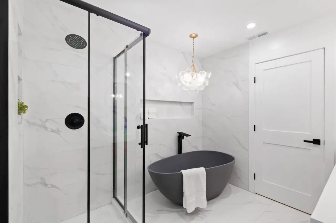 Guest bath with soaking tub, niche and warm metal accents