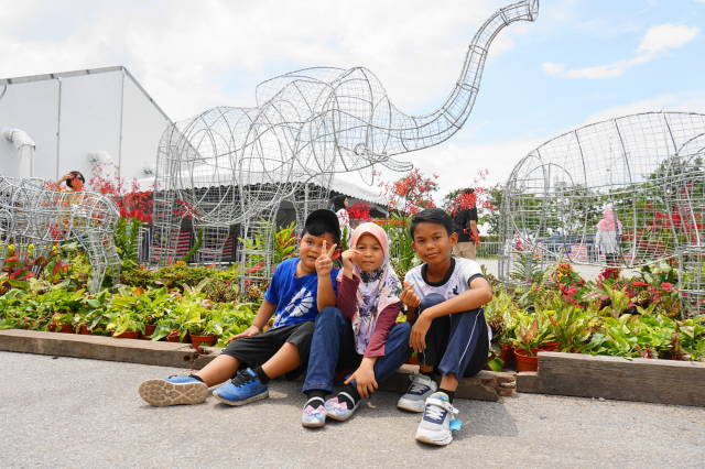 bergambar berlatar belakang arca besi haiwan gajah