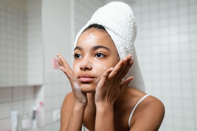 a woman applying acidic cleanser to balance her skin's natural pH