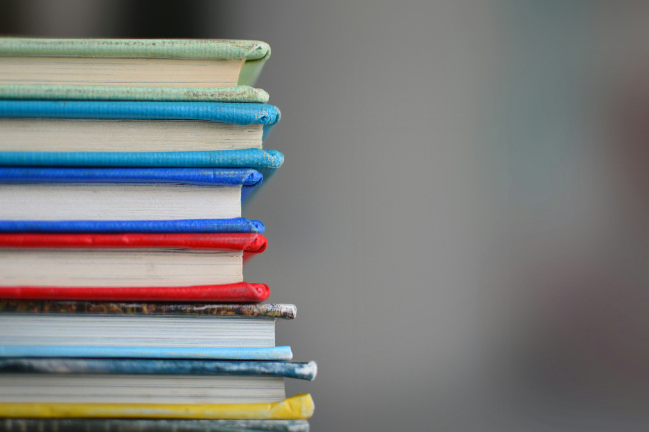 Unsplash image of a stack of colorful books by Kimberly Farmer