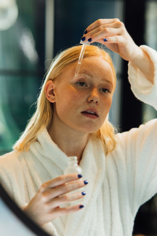 a woman using glycerin containing serum on her face to make her skin soft, smooth and hydrated 