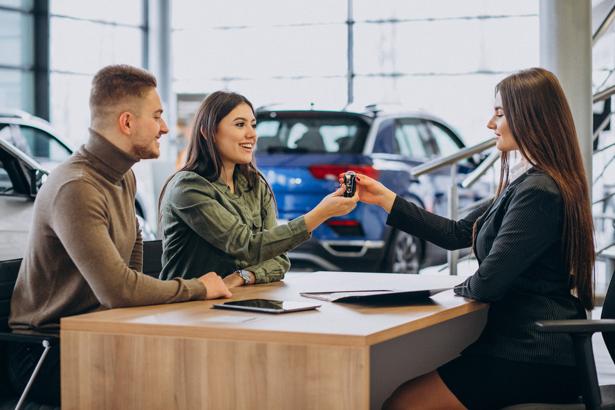 Common Myths About Buying Used Cars Young-couple-talking-sales-person-car-showroom-Easy-Resize-com