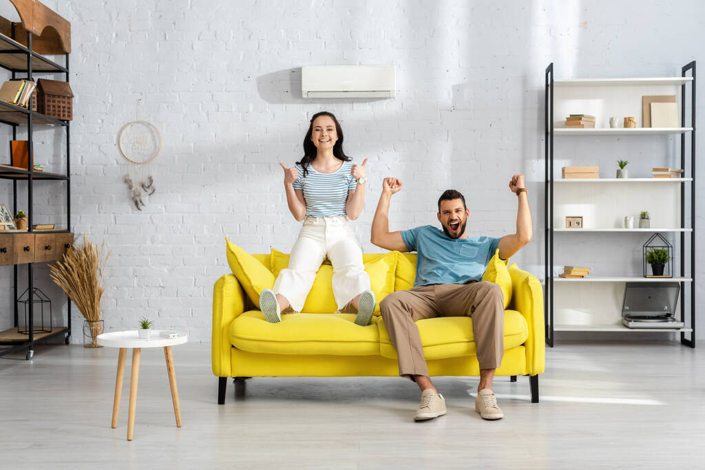 Happy couple giving thumbs up for comfortable air