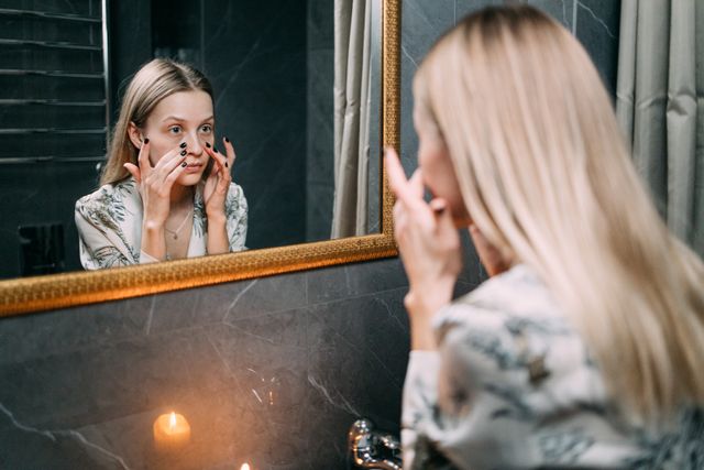  a woman with flaky, dry skin exfoliating her skin to deal with fall dryness