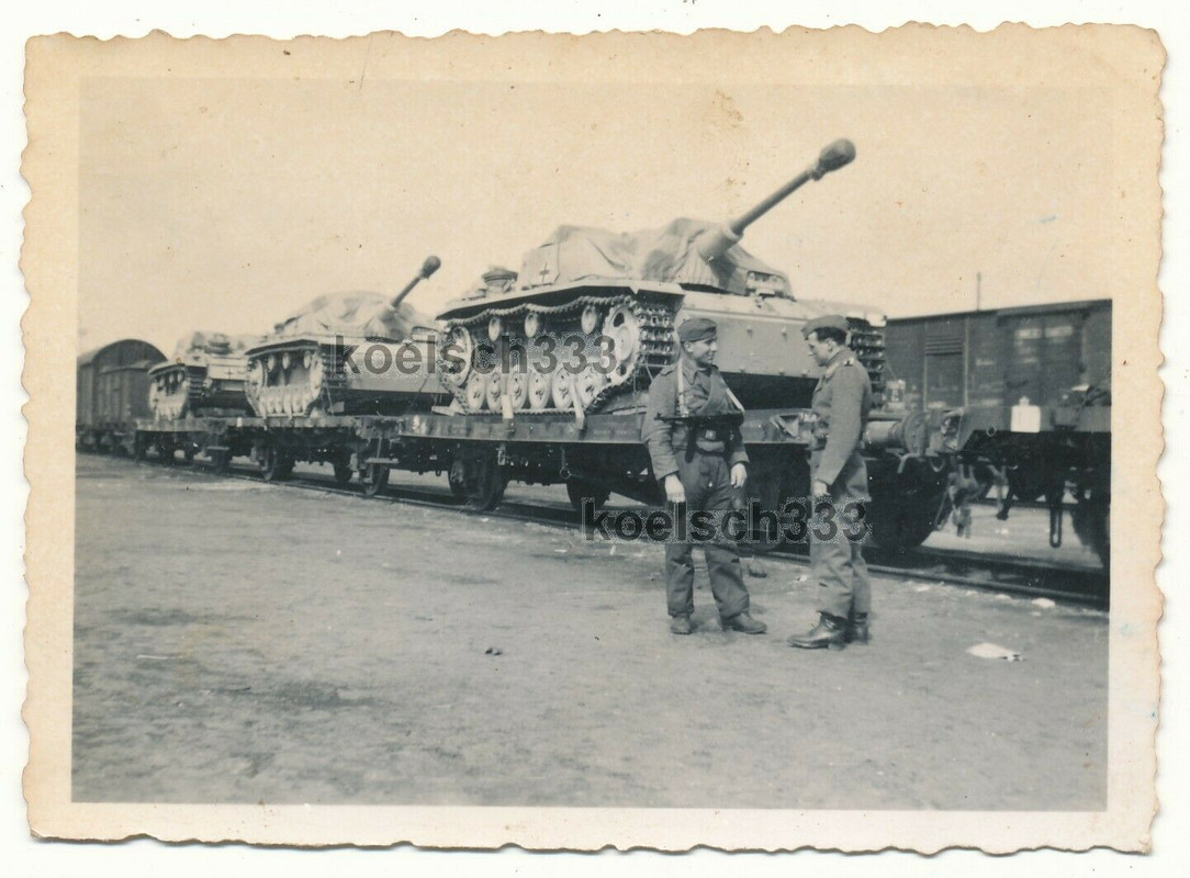 Foto Panzermann mit MP 40 vor Sturmgeschütz Panzern auf Eisenbah