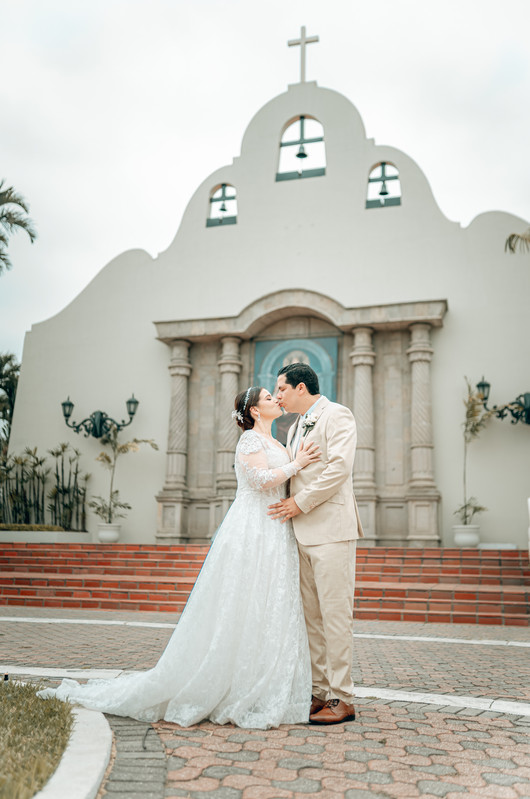 Esposos afuera de la iglesia, beso romántico sin gente