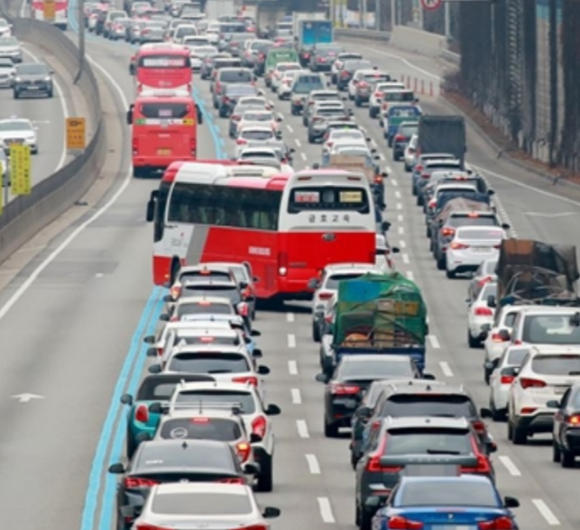 Red buses using the dedicated bus-only lane on a congested Korean expressway while other traffic is stopped