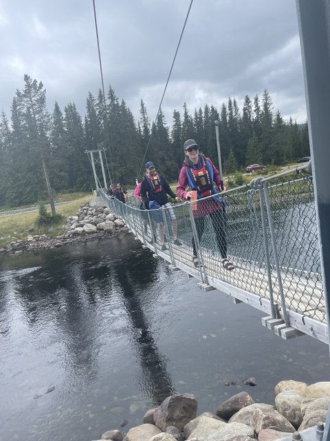 Beer holders walking across a bridge