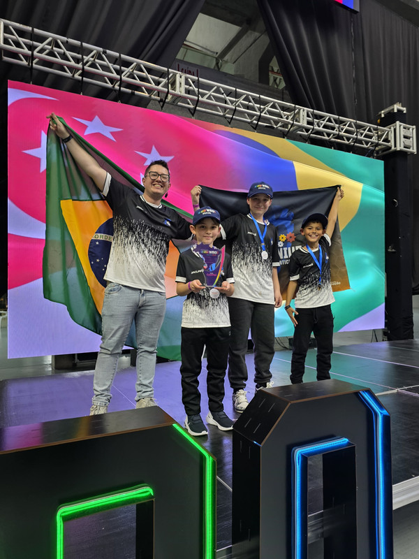 A equipe AstroGenius Orion com seu robô e troféus