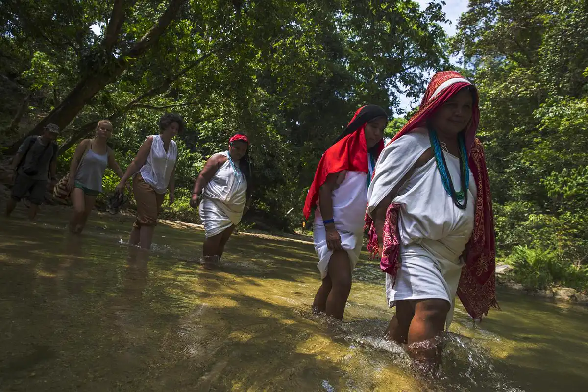 Indigenous women of the Sierra Nevada crossing the river
