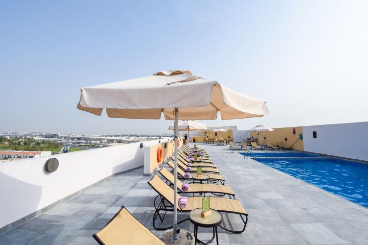 مسبح فندق Premier Inn Dubai International Airport مع الكراسي