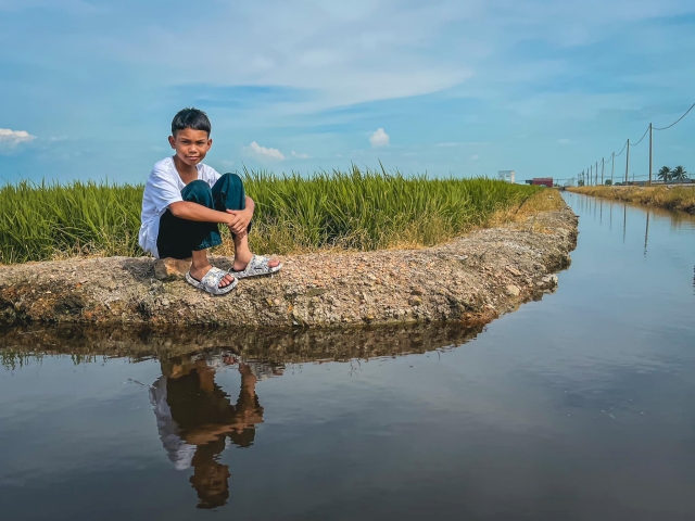 Abang Aslah bergambar di tali air sawah