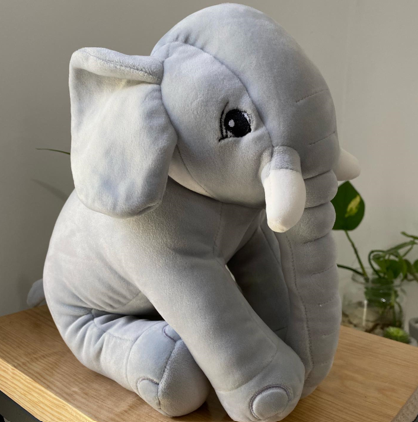 A stuffed elephant on a table Description automatically generated