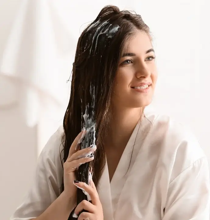 The girl applies cinnamon and hair conditioner