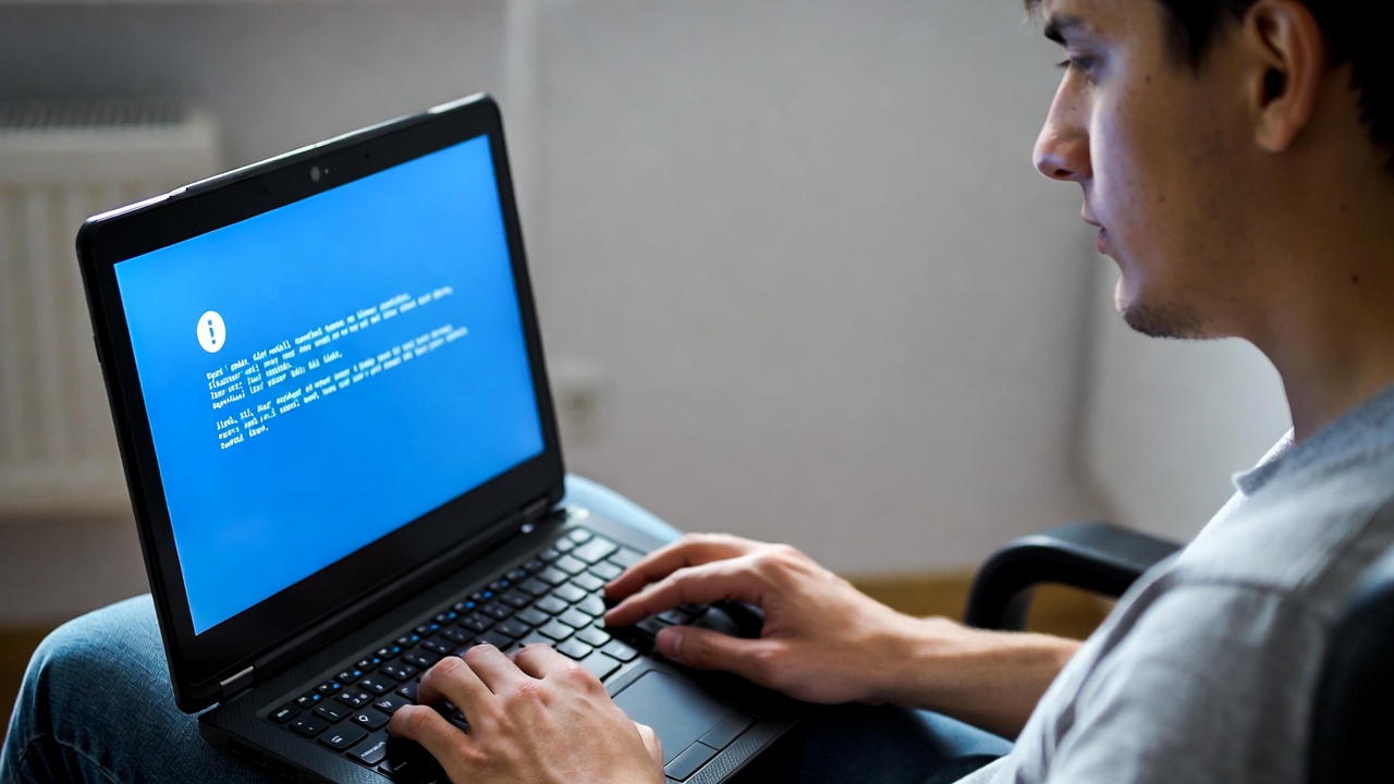 Person looking at slow laptop with error message on screen