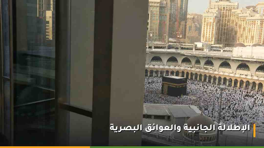 إطلالة جزئية على المسجد الحرام من نافذة فندقية يحجبها عمود إنشائي