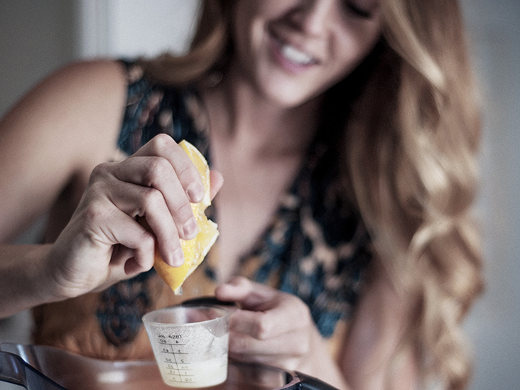 A girl with light curly hair squeezes a lemon to lighten her hair