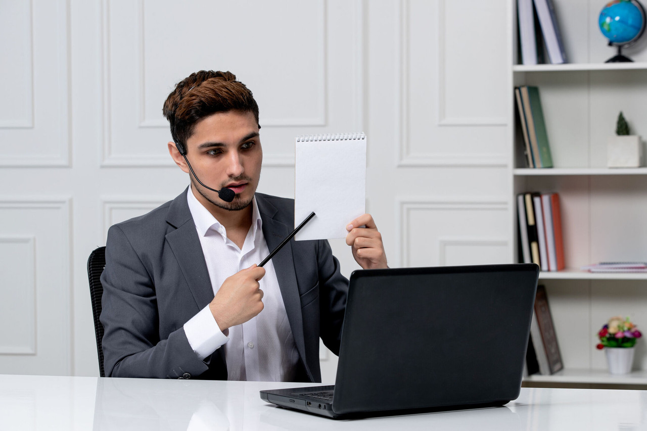customer service young cute guy grey office suit with computer showing notes paper optimized 2000 1
