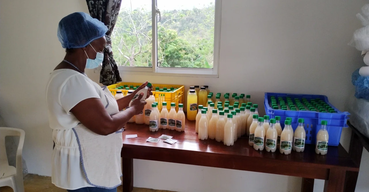 Mujer añadiendo etiquetas a jugos para su venta
