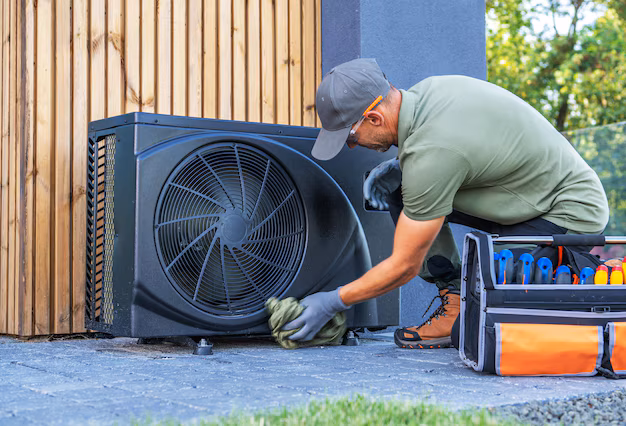 Technician performing AC outdoor unit maintenance