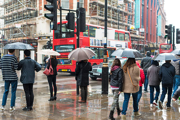 A picture of a rainy London street with multiple people carrying umbrellas.