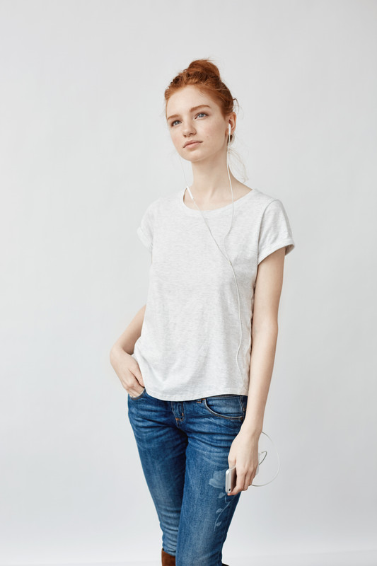 Fata tanara imbracata in tricou alb asculta muzica