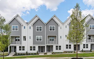Three-story townhomes with gray and white siding and small balconies