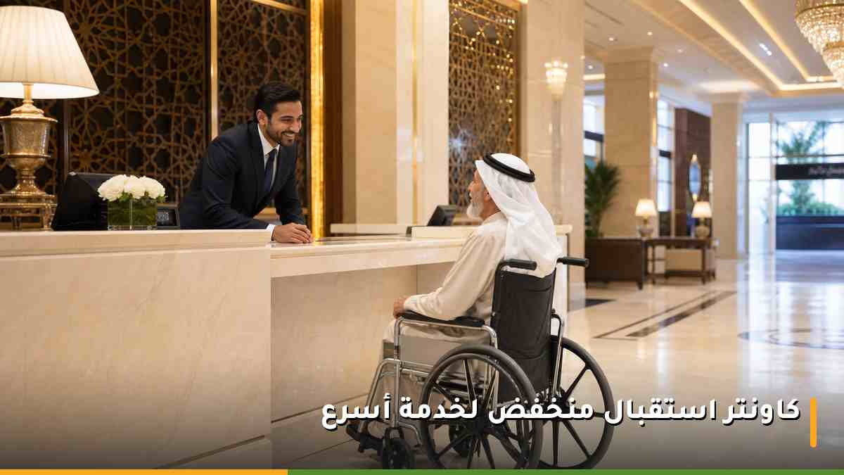 موظف استقبال في فندق بمكة يخدم نزيلًا مسنًا على كرسي متحرك عند كاونتر منخفض
