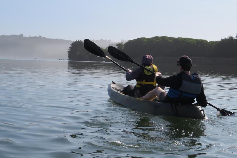 Dos personas en kayak doble sobre el río Rapel con neblina