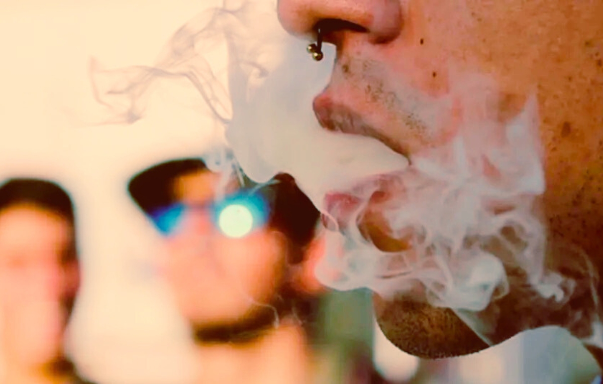joven sacando humo blanco despues de fumar