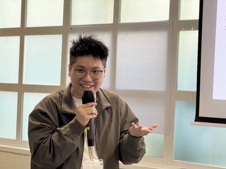 Chris smiling and speaking into a microphone during a workshop