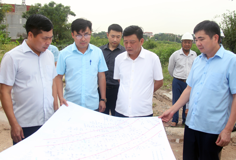Đồng chí Ngô Tân Phượng kiểm tra sơ đồ mặt bằng đường Vành đai 4 tại phường Hạp Lĩnh