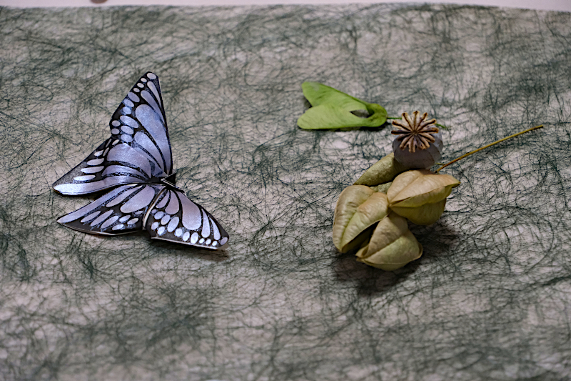 Déco de table, un papliion en papier et des graines