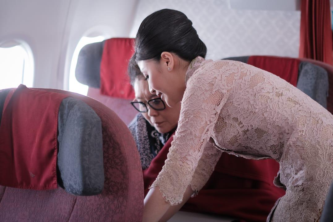 Pramugari Garuda Indonesia sedang melayani penumpang