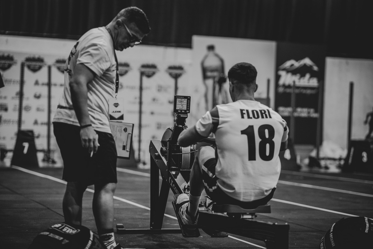 Personal trainer coaching a client through a conditioning exercise in a gym