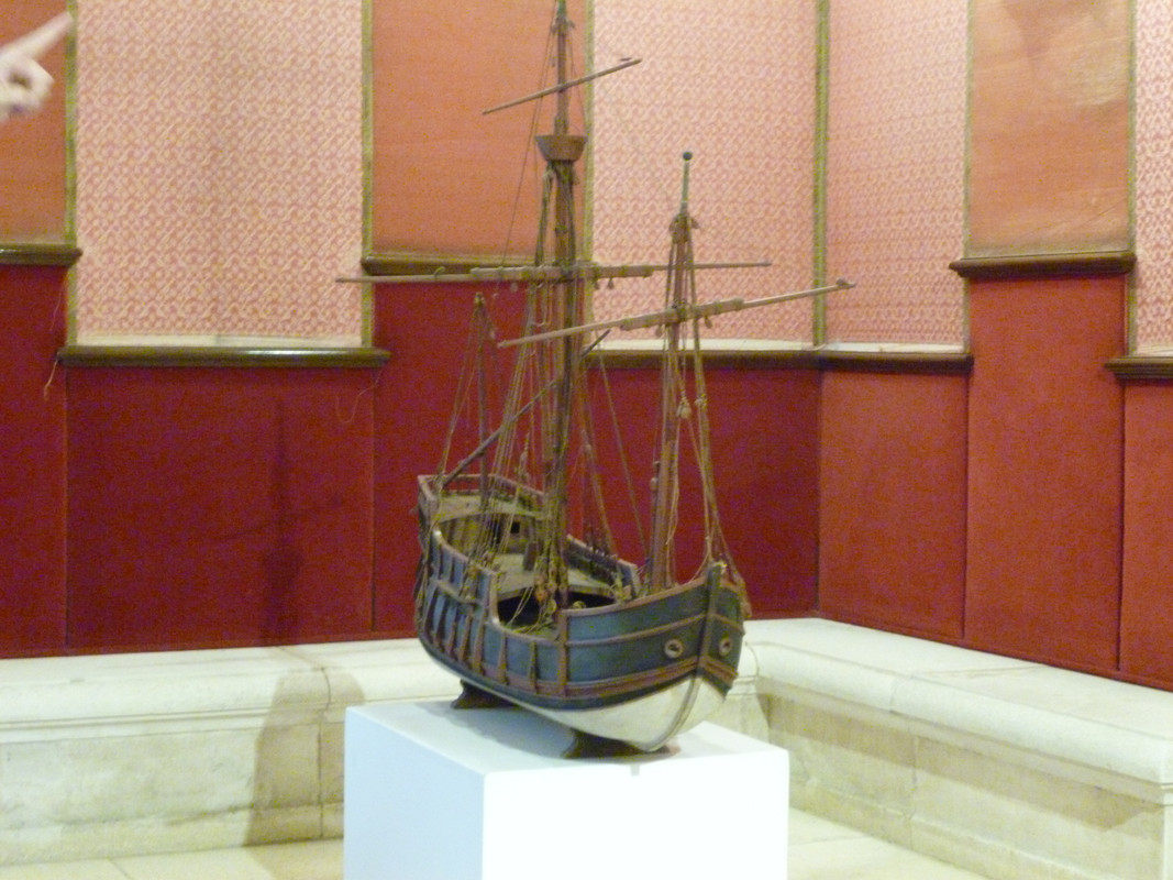 A wooden boat with a painted white hull and blue sides.  It has two masts and no sails