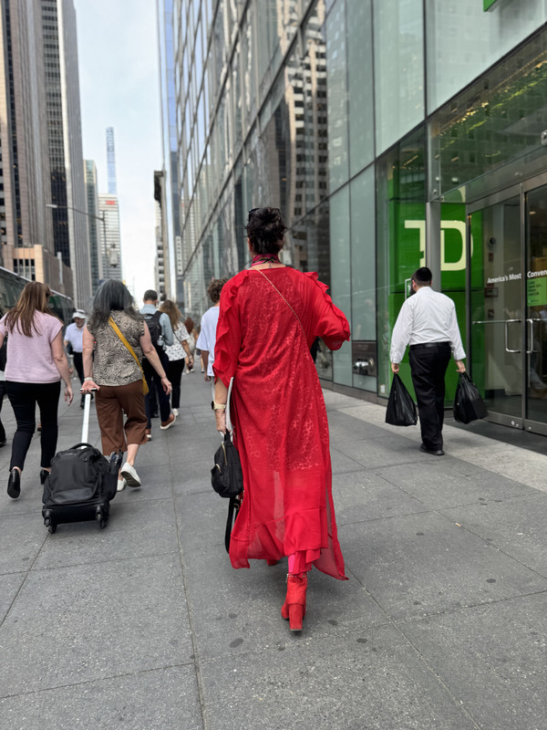 Gin walking a New York street in a red coat